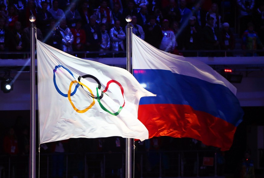 epa05439101 (FILE) A file picture dated 23 February 2014 of the Olympic flag (L) and the Russian flag (R) during the Closing Ceremony of the Sochi 2014 Olympic Games in the Fisht Olympic Stadium in So ...