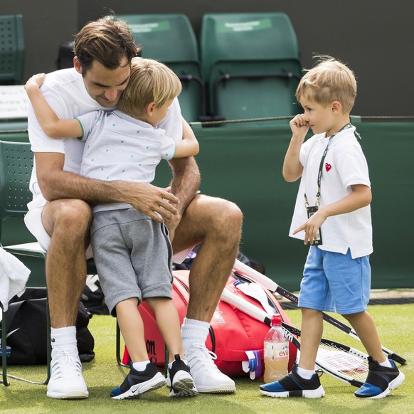 epa06847963 Roger Federer of Switzerland hugs his twin boys Leo and Lenny at the end of a training session at the All England Lawn Tennis Championships in Wimbledon, London, 28, June 2018. The Wimbled ...