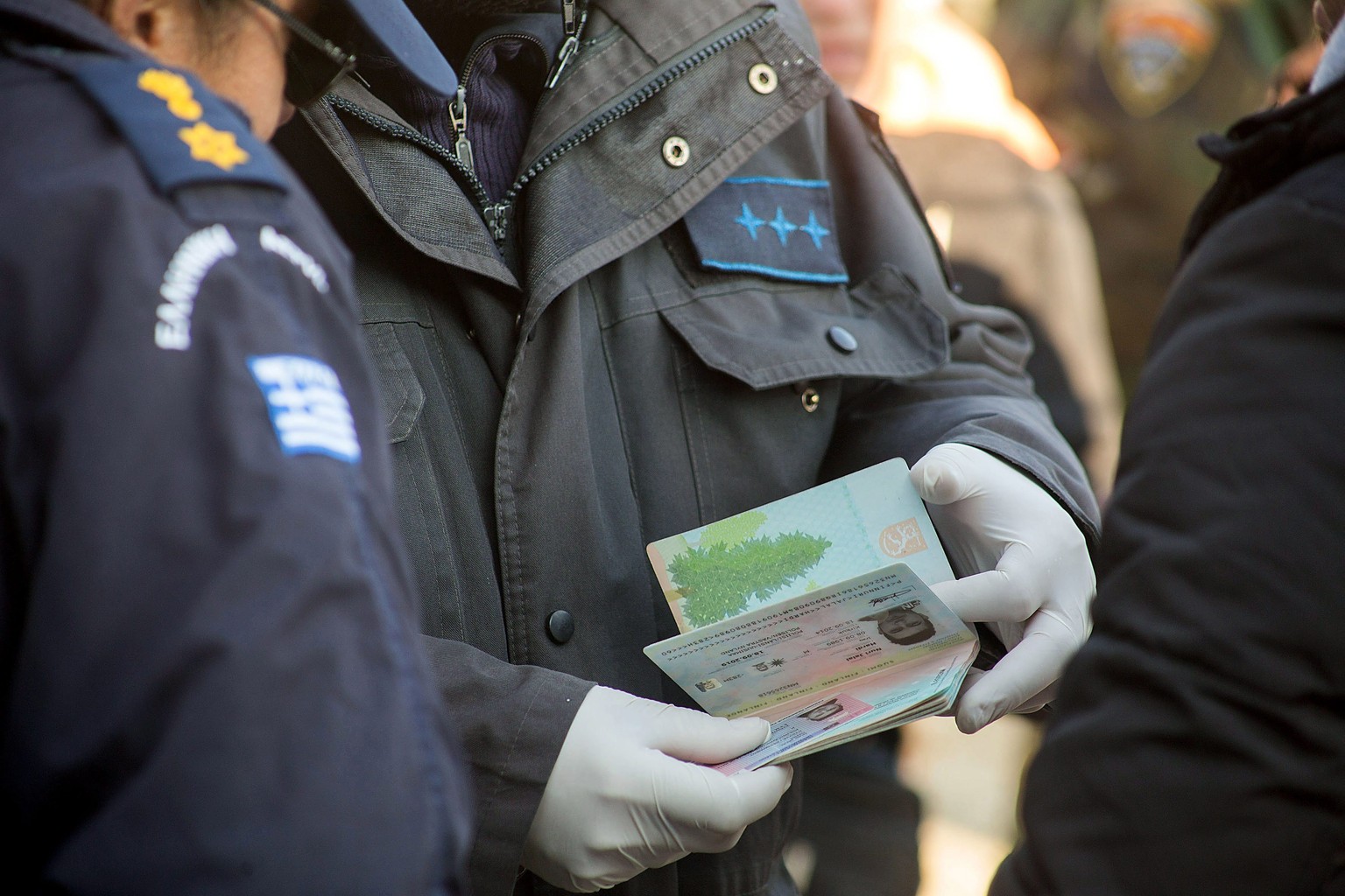 Griechische Polizisten prüfen die Papiere von Flüchtlingen.