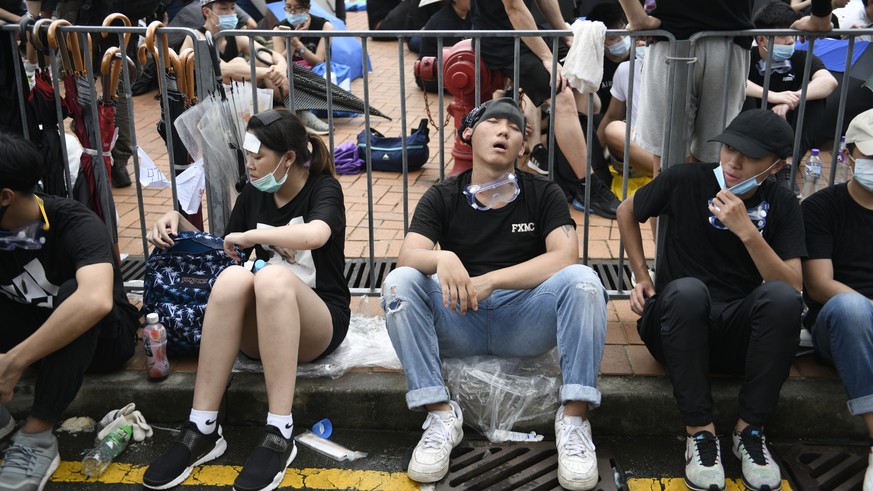 epaselect epa07642806 Protesters rest around barricades during a rally against an extradition bill outside the Legislative Council in Hong Kong, China, 12 June 2019. The bill, scheduled for a second r ...