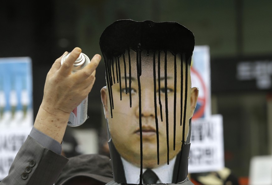 A picture of North Korean leader Kim Jong Un is sprayed by an anti-North Korean protester during an anti-North Korea rally against recent missile launches and provocative acts, on the birthday of its  ...