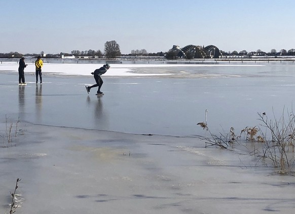 People skate on the ice of frozen flood plains of Nederrijn river near Doorwerth, Netherlands, Thursday, Feb. 11, 2021. The deep freeze gripping parts of Europe served up fun and frustration with heav ...