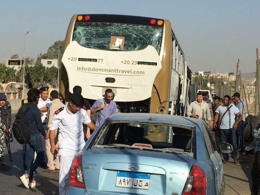 CORRECTS DATE PHOTO TAKEN - Police inspect a car and a bus that were damaged by a bomb, in Cairo, Egypt, Sunday, May 19, 2019. Egyptian officials say a roadside bomb has hit a tourist bus near the Giz ...