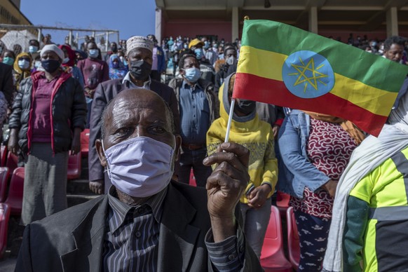 A man holds a national flag as he waits in the stands to give blood at a blood drive in support of the country&#039;s military, at a stadium in the capital Addis Ababa, Ethiopia Thursday, Nov. 12, 202 ...