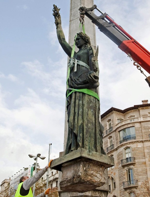 epa02556656 A worker helps during the removal of a statue that commemorates the victory of Francisco Franco in the Spanish Civil War, Barcelona, northeastern Spain, 30 January 2011, to observe the His ...