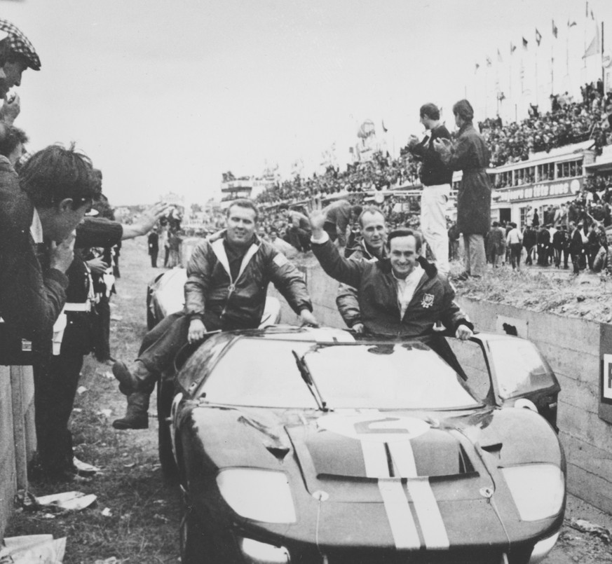 New Zealand&#039;s Chris Amon, right, waves to the crowd from his 7-litres Ford automobile after he and compatriot Bruce McLaren, not shown, won the 24-hours endurance for sports cars, at Le Mans, Fra ...