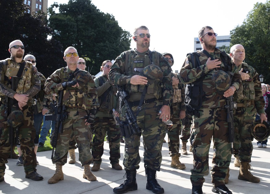 Michigan Home Guard militia members stand at attention as the National Anthem is sung during the Second Amendment March at the State Capitol, Thursday, Sept. 17, 2020, in Lansing, Mich. Dozens gathere ...