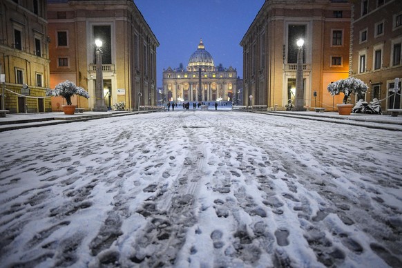 epa06565703 Via della Conciliazione close to Saint Peter square is covered by snow during a snowfall in Vatican, Italy, 26 February 2018. Schools and public offices were closed and snow-removal crews  ...