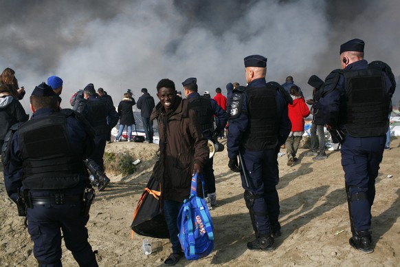 epa05603720 Migrants and french police in the makeshift camp known as the Jungle in Calais, France, 25 October 2016. The camp in Calais gathering more than 7,000 migrants has started being dismantled, ...
