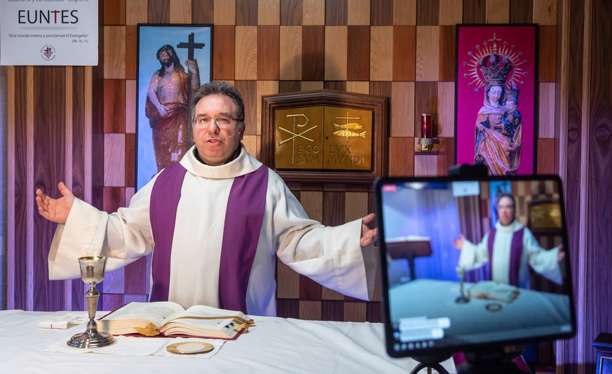 epaselect epa08340379 Priest Jose Luis Hernandez conducts a mass via internet through the social media while he looks at pictures sent by neighbors to fight loneliness in Quel, La Rioja, Spain, 03 Apr ...