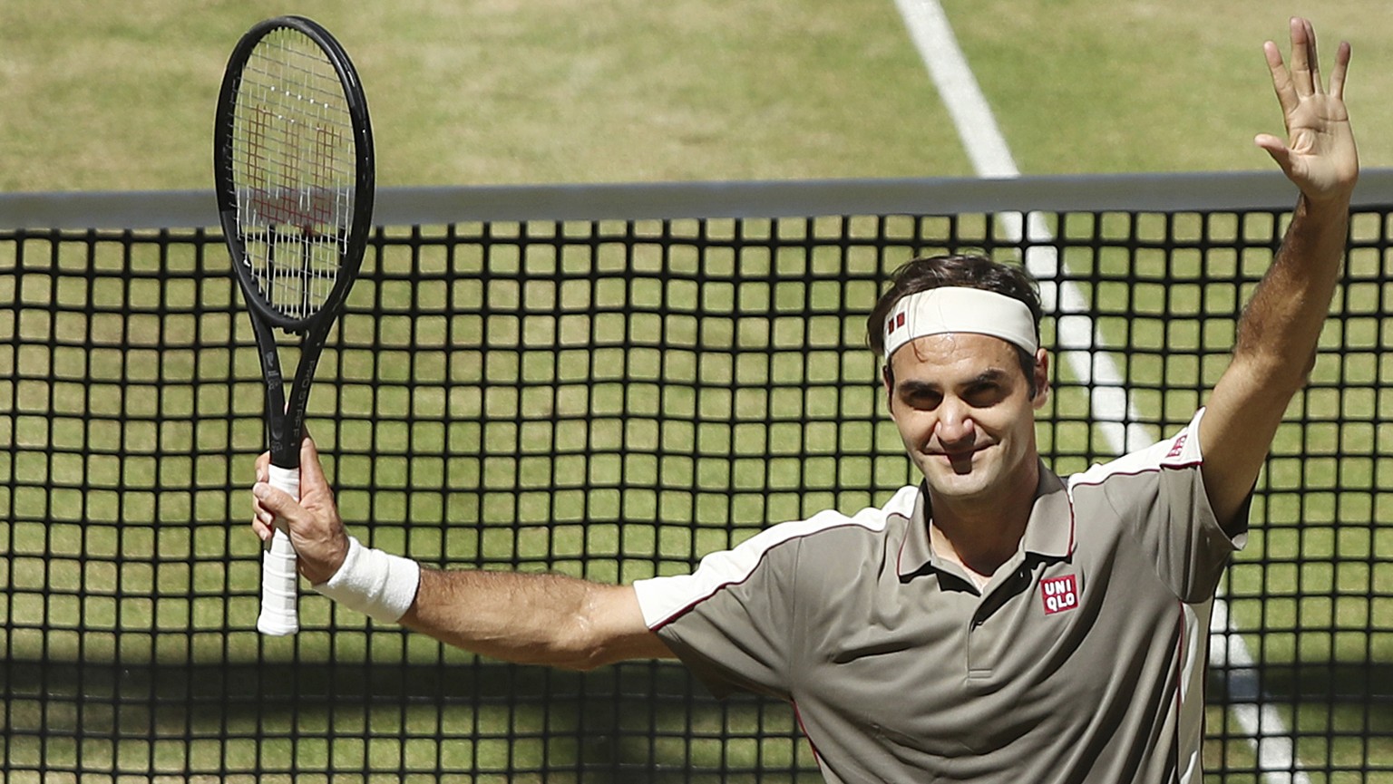 Swiss Roger Federer celebrates after winning the tennis ATP final against Belgium David Goffin in Halle, Germany, Sunday, June 23, 2019. (Friso Gentsch/dpa via AP)