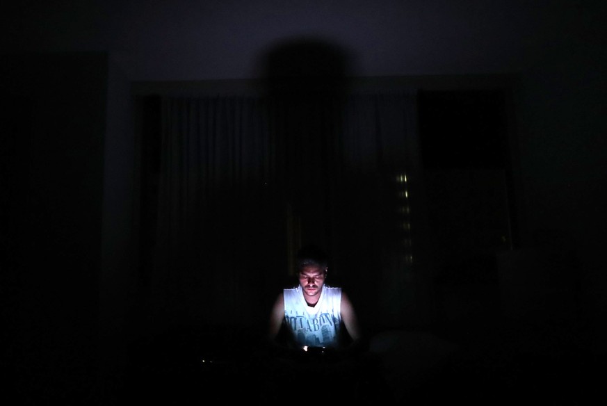 epa07421289 A man looks a mobile phone in the dark during a power outage in Caracas, Venezuela, 07 March 2019. Venezuela suffered a power outage on 07 March that saw at least 14 states affected, inclu ...