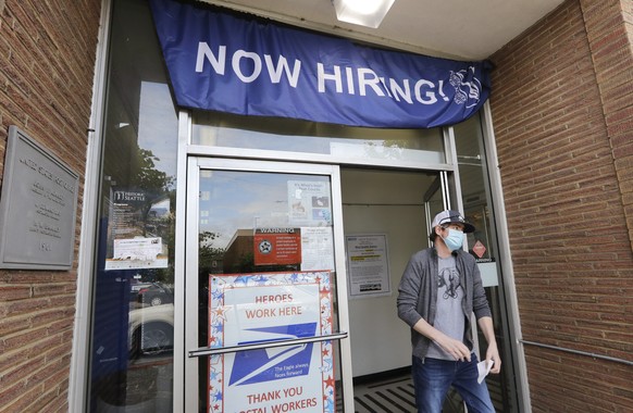 FILE - In this Thursday, June 4, 2020 file photo, a customer walks out of a U.S. Post Office branch and under a banner advertising a job opening, in Seattle. The job market took a big step toward heal ...