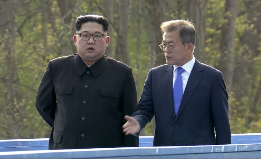 In this image made from video provided by South Korea Host Broadcast, North Korean leader Kim Jong Un, left, and South Korean President Moon Jae-in, right, talk as they walk on blue bridge in the bord ...