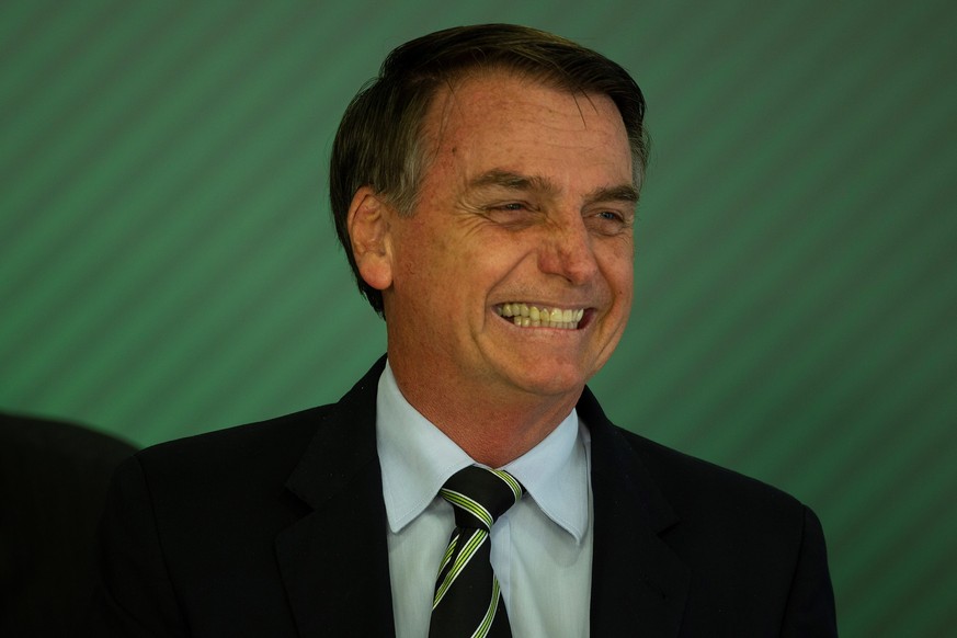 epa07287007 Brazilian President Jair Bolsonaro reacts after signing the bill to facilitate weapon possession in the country, in Brasilia, Brazil, 15 January 2019. Greater access to possession of arms  ...