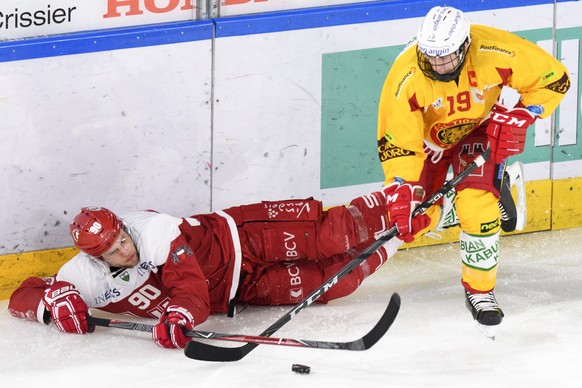 le defenseur lausannois Jannik Fischer, gauche, lutte pour le puck avec l’attaquant de Langnau Pascal Berger, droite, lors de la rencontre du championnat suisse de hockey sur glace de National League  ...