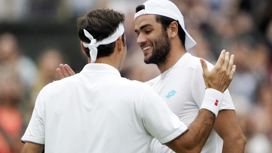 epa07704144 Roger Federer of Switzerland (L) at the net with Matteo Berrettini of Italy whom he defeated in their fourth round match during the Wimbledon Championships at the All England Lawn Tennis C ...