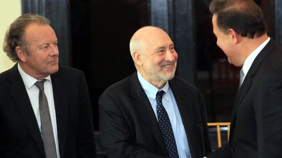 epa05283568 Nobel Prize of Economy 2001, Joseph Stiglitz (C) greets Panamanian President Juan Carlos Varela (R) as Swiss academic lawyer and anti-corruption expert Mark Pieth (L) looks on during a cer ...