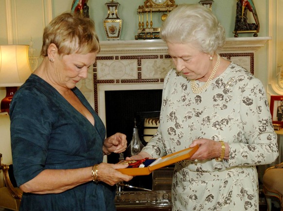 Britain&#039;s Queen Elizabeth II invests Oscar-winning actress Dame Judi Dench with the Insignia of a Companion of Honour at Buckingham Palace, in London, Wednesday Oct. 26, 2005.(AP Photo/Fiona Hans ...