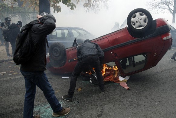 epa08001239 Masked protesters overturn a car as they clash with riot police during the &#039;Gilets Jaunes&#039; (Yellow Vests) &#039;Act 53&#039; demonstration (the 53rd consecutive national protest  ...