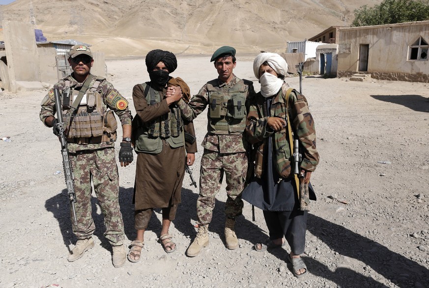 epa06814115 Alleged Taliban militants greet Afghan Army soldiers as a group of Taliban visits people as a goodwill gesture amid a three-day ceasefire on second day of Eid al-Fitr, in Kabul, Afghanista ...