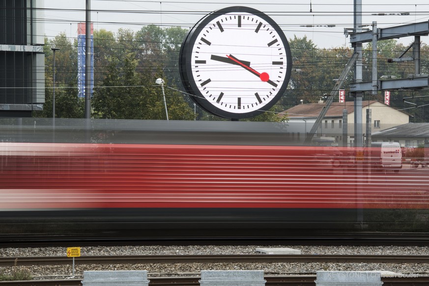 A train passes a large station clock in front of the new company headquarters of Swiss Federal Railway (by architects Lussi and Halter), captured in Bern on October 2, 2014 (Christian Beutler) 

Ein Z ...