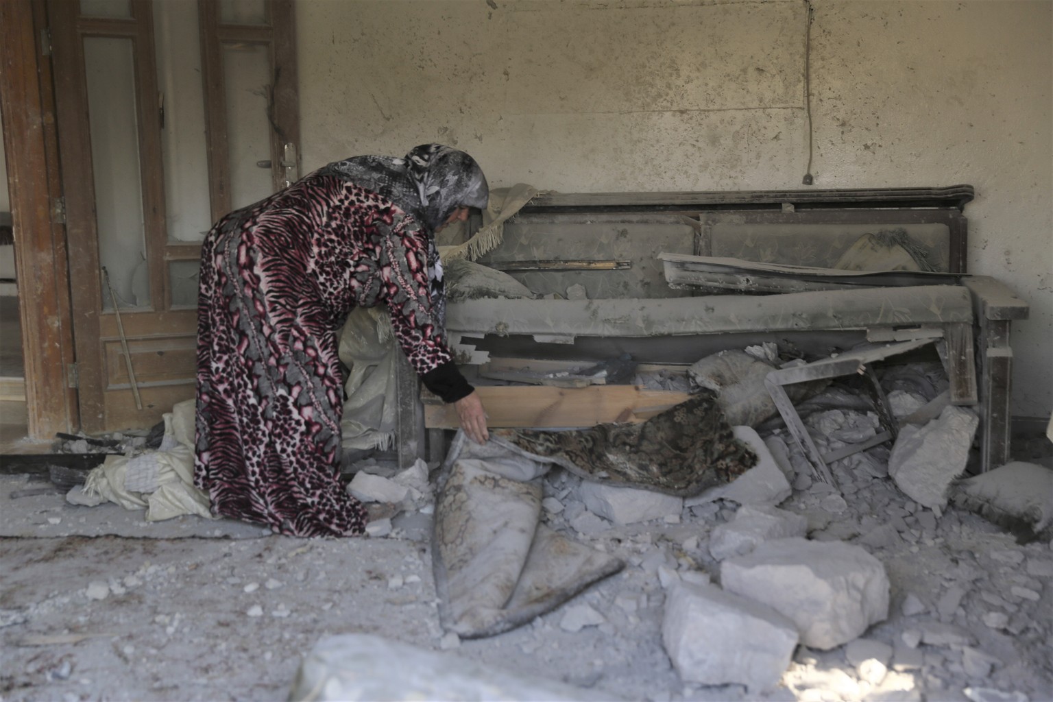 A woman checks damage to her home in the village of Barisha, in Idlib province, Syria, Sunday, Oct. 27, 2019, after an operation by the U.S. military which targeted Abu Bakr al-Baghdadi, the shadowy l ...