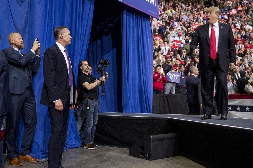 Brad Parscale, manager of President Donald Trump&#039;s reelection campaign, left, holds up his smart phone as President Donald Trump, right, takes the stage at a rally at Resch Center Complex in Gree ...