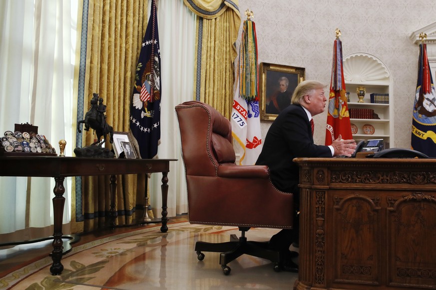 President Donald Trump greets members of the five branches of the military by video conference on Christmas Day, Tuesday, Dec. 25, 2018, in the Oval Office of the White House. The military members wer ...