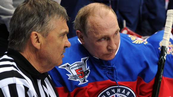 Russian President Vladimir Putin, right, speaks with IIHF President Rene Fasel as he takes part in a gala match of the Night Hockey League in the Bolshoy Ice Dome in the Black Sea resort of Sochi, Rus ...