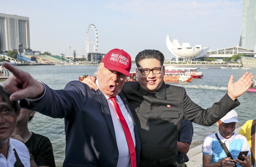 epa06792904 US President Donald Trump impersonator Dennis (L) and North Korean leader Kim Jong-un impersonator Howard (C-R) pictured against the Singapore Flyer and Marina Bay as they pose for photogr ...