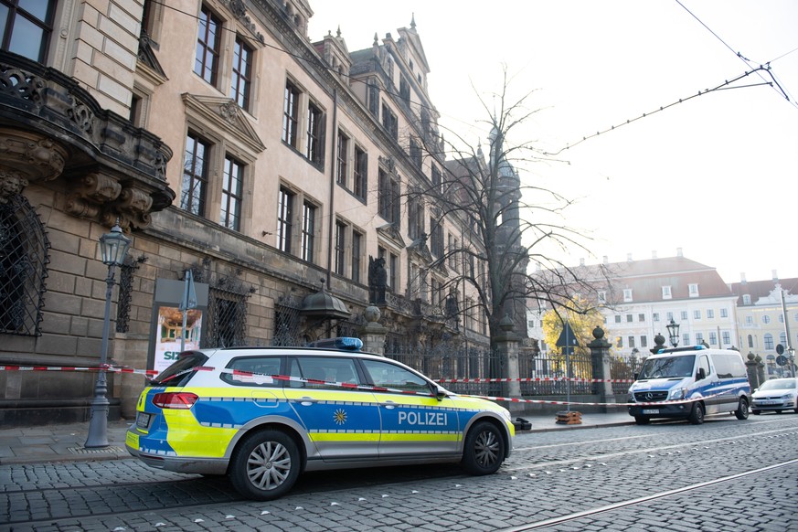 25.11.2019, Sachsen, Dresden: Polizeifahrzeuge stehen vor dem Residenzschloss mit dem Grünen Gewölbe hinter einem Absperrband. In Dresdens Schatzkammer Grünes Gewölbe ist am frühen Morgen eingebrochen ...