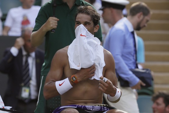 Rafael Nadal of Spain changes his shirt in a game break during the men&#039;s quarterfinal match against Juan Martin Del Potro of Argentina at the Wimbledon Tennis Championships in London, Wednesday J ...