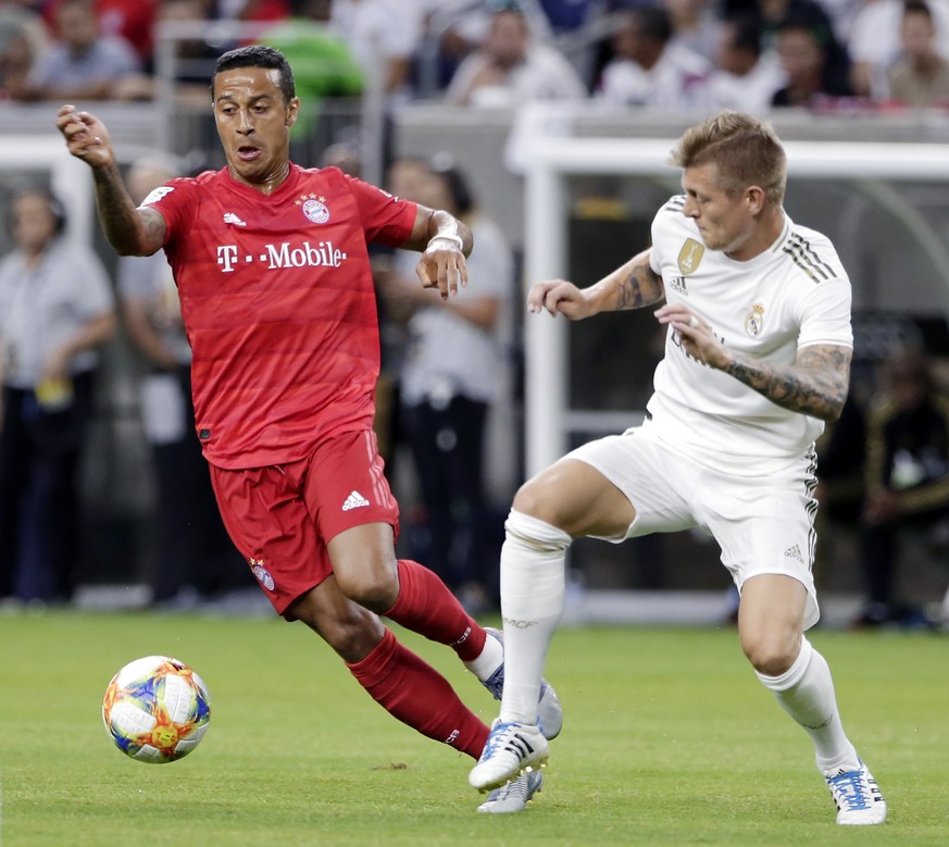 FC Bayern midfielder Thiago, left, moves the ball past Real Madrid midfielder Toni Kroos during the first half of an International Champions Cup soccer match Saturday, July 20, 2019, in Houston. (AP P ...