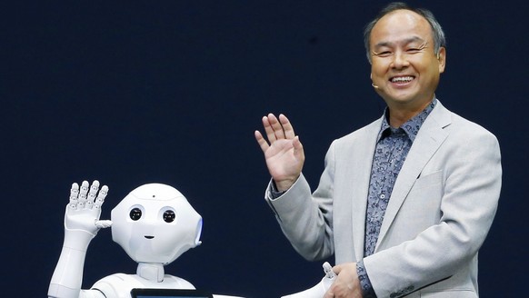 Softbank Corp. President Masayoshi Son, right, and Pepper, a newly developed robot, wave together during a press event in Urayasu, near Tokyo, Thursday, June 5, 2014. The cooing, gesturing humanoid on ...