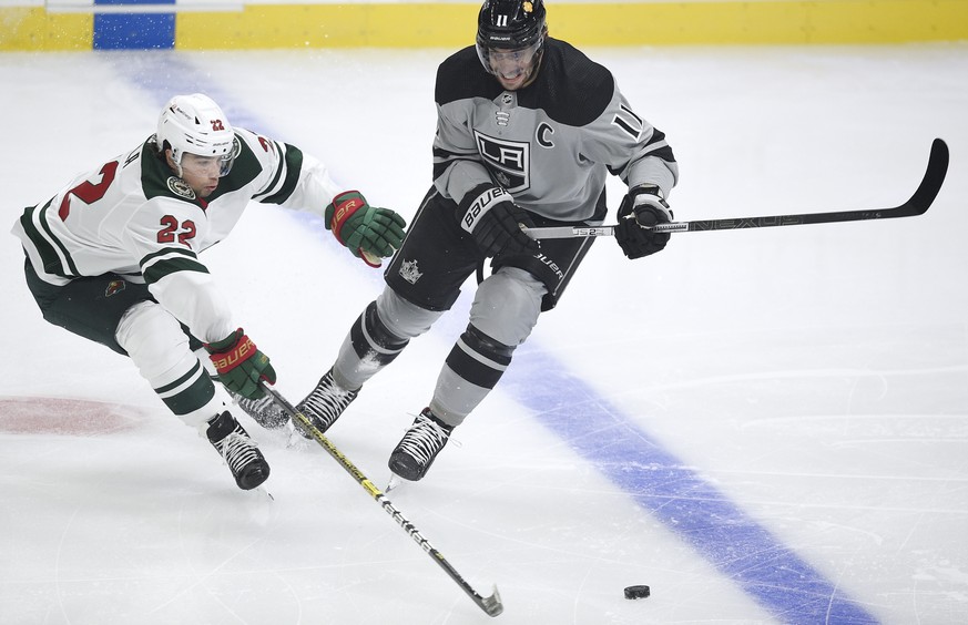 Minnesota Wild left wing Kevin Fiala, left, lunges to poke the puck away from Los Angeles Kings center Anze Kopitar during the first period of an NHL hockey game in Los Angeles, Saturday, Jan. 16, 202 ...