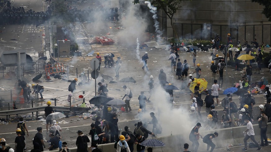 Riot police fire tear gas toward protesters outside the Legislative Council in Hong Kong, Wednesday, June 12, 2019. Hong Kong police have used tear gas and high-pressure hoses against thousands of pro ...