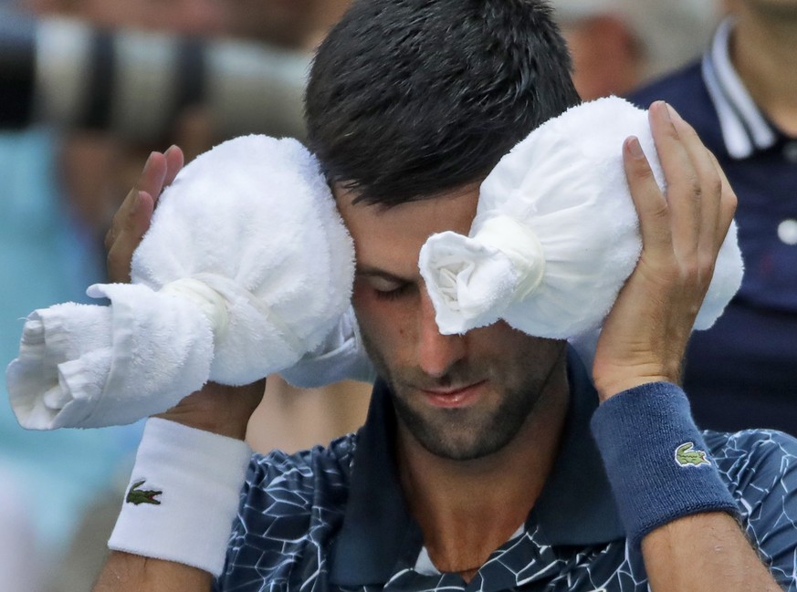Novak Djokovic, of Serbia, puts an ice towel around his head during a changeover against Joao Sousa, of Portugal, during the fourth round of the U.S. Open tennis tournament, Monday, Sept. 3, 2018, in  ...
