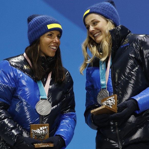 Silver medalists in the women&#039;s team sprint freestyle cross-country skiing Stina Nilsson and Charlotte Kalla, of Sweden, smile during the medals ceremony at the 2018 Winter Olympics in Pyeongchan ...