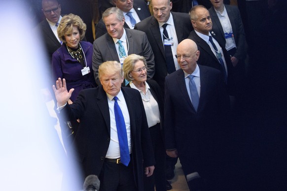 epa06473838 US President Donald Trump (L) arrives at the Congress Center next to Hilde Schwab (C), Chairperson and Co-Founder of Schwab Foundation for Social Entrepreneurship and Klaus Schwab (R), Fou ...