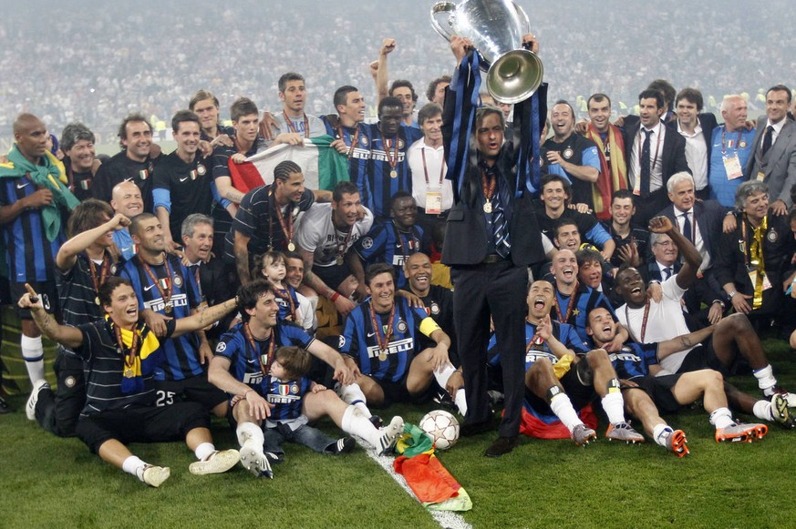 Inter Milan coach Jose Mourinho holds up the trophy surrounded by his team after winning the Champions League final soccer match between Bayern Munich and Inter Milan at the Santiago Bernabeu stadium  ...