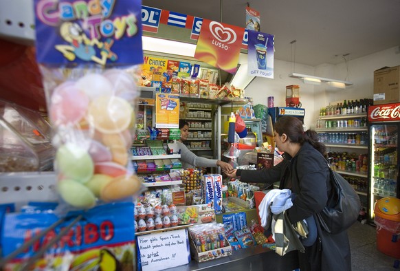 Eine Kundin kauft bei einem privaten Kiosk am Kannenfeldplatz in Basel ein, am 5. Oktober 2006. Im Kanton Basel-Stadt gelten fuer Familienbetriebe im Verkaufssektor erweiterte Ladenoeffnungszeiten. Wa ...