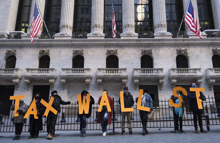epa08972091 Activists gather in front of the New York Stock Exchange as part of a protest calling for an increase in the capital gains tax in New York, New York, USA, 28 January 2021. New York State i ...