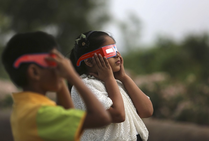Indian children watch a partial solar eclipse in Hyderabad, India, Wednesday, March 9, 2016 Indian people in northeast and eastern coastal strip of the sub-continent viewed a partial solar eclipse as  ...