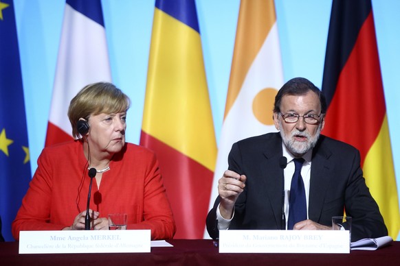 German Chancellor Angela Merkel listens to Spanish Prime Minister Mariano Rajoy during a joint press conference at the Elysee Palace in Paris, Monday, Aug.28, 2017. The leaders of France, Germany, Ita ...