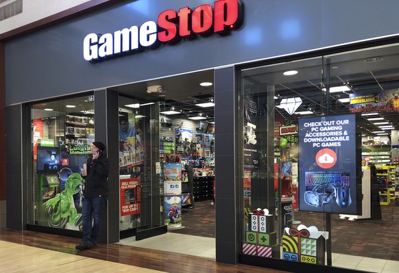 epa08971011 (FILE) - A man talks on a cell phone outside a GameStop store in Gurnee, Illinois, USA, 10 December 2019 (reissued 28 January 2021). The electronic game retailer has seen it&#039;s stock p ...