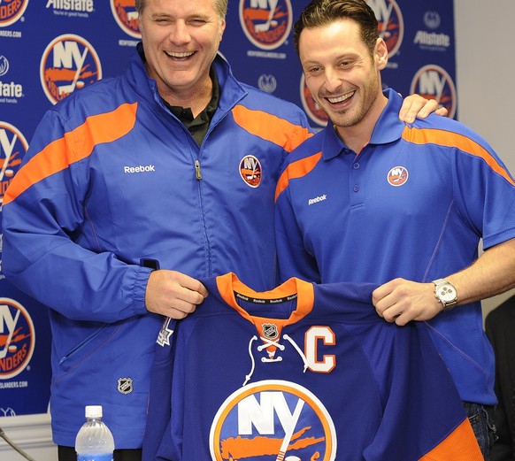 New York Islanders general manager Garth Snow, left, and newly-named captain Mark Streit smile during a news conference at NHL hockey training camp at Nassau Coliseum in Uniondale, N.Y., Wednesday, Se ...
