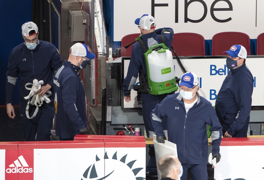 Arena workers clean the players&#039; bench before NHL hockey action between the Edmonton Oilers and the Montreal Canadiens, in Montreal, Thursday, Feb. 11, 2021. The game had been delayed by an hour  ...