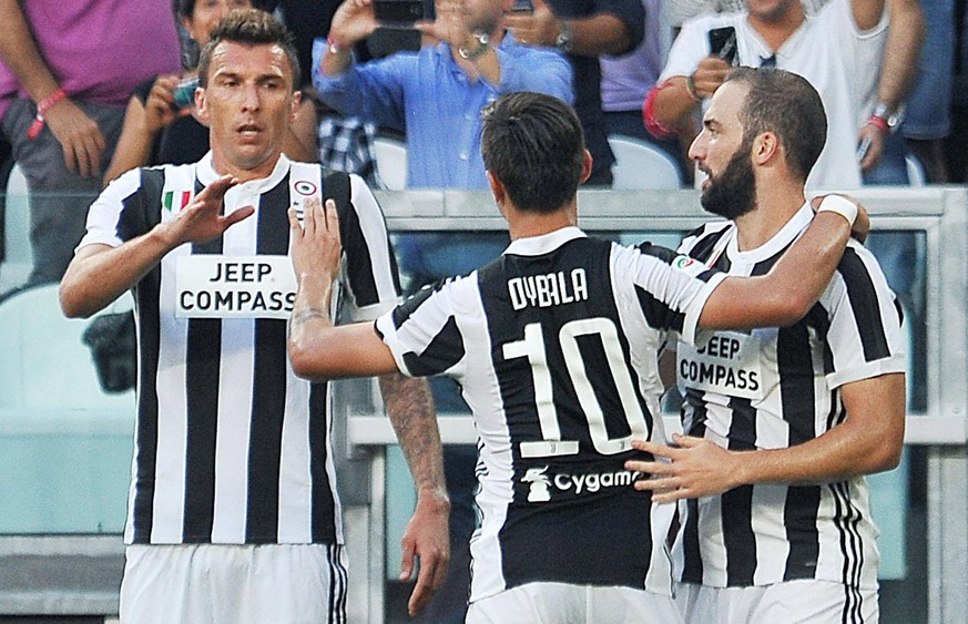 epa06152134 Juventus&#039; Gonzalo Higuain (R) celebrates with teammates Paulo Dybala (C) and Mario Mandzukic (L) after scoring during the Italian Serie A soccer match between Juventus and Cagliari at ...