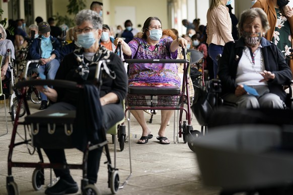 FILE - In this Jan. 12, 2021, file photo Resident Sabeth Ramirez, 80, center, waits in line with others for the Pfizer-BioNTech COVID-19 vaccine at the The Palace assisted living facility in Coral Gab ...